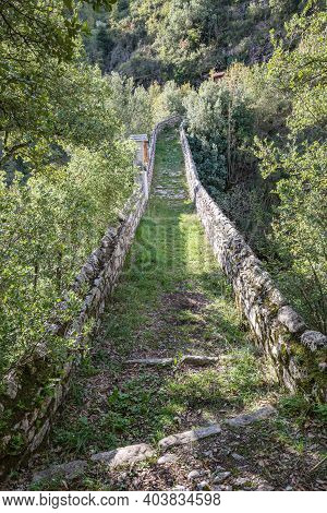 Old Stone Bridge Leading To Small Mountain Village With A Few Remaining Residents