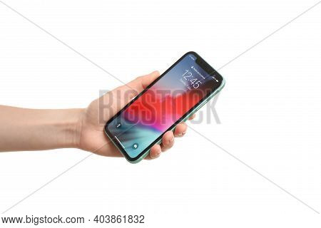 Mykolaiv, Ukraine - June 9, 2020: Woman Holding  Iphone X With Locked Screen On White Background, Cl