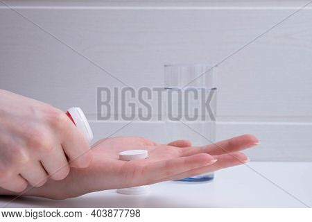 Female Hand Lays Down A Tablet On The Palm On A Gray Background