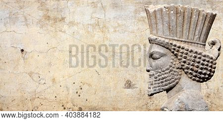 Ancient wall with bas-relief with assyrian warriors, Persepolis, Iran. UNESCO world heritage site. Horizontal background with embossed image persian bearded man. Mock up template. Copy space for text