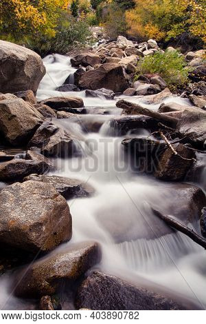 Photograph Of A Beautiful Cascading Waterfalls Rushing Down A Steep Incline In The Rocky Mountains O