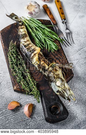 Cooked Mackerel Icefish On A Wooden Cutting Board. Black Background. Top View