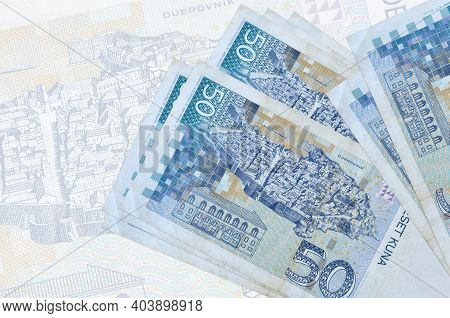 50 Croatian Kuna Bills Lies In Stack On Background Of Big Semi-transparent Banknote. Abstract Presen