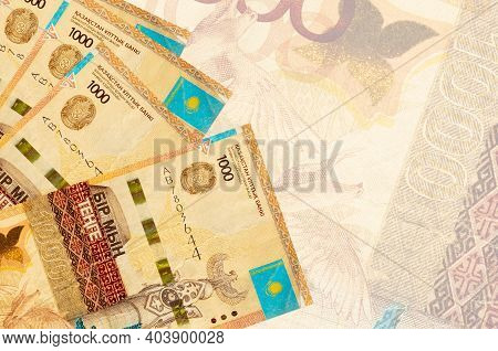 1000 Kazakhstani Tenge Bills Lies In Stack On Background Of Big Semi-transparent Banknote. Abstract 