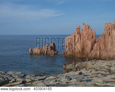 Arbatax, Sardinia, Italy, September 9, 2020: Two Young Men Jumping From Red Rocks, Rocce Rosse At Me