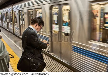 Tokyo, Japan - October 19, 2017: Businessman Waiting For A Subway Of Tokyo Metro In Tokyo Japan