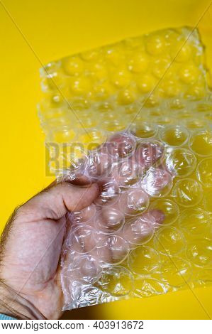 Pov Male Hand Holding Hand Under Bubblewrap Protection Material With Ultra-large Bubbles