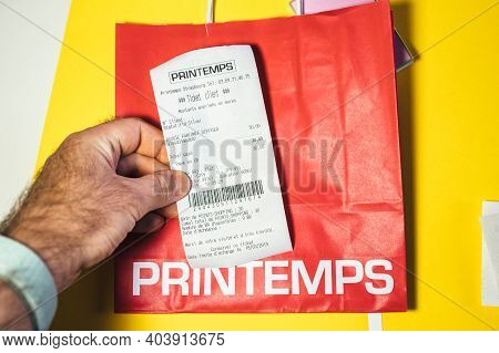 Paris, France - Feb 17, 2019: Pov Male Hand Holding Printania Paper Slip From Luxury Department Fren