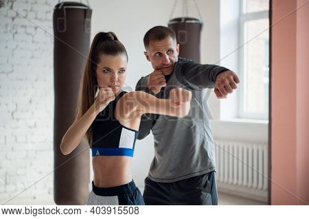 In A Spacious Loft, A Male Trainer And His Female Mentee Conduct A Boxing Training Session