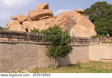 Hampi, Karnataka, India - November 5, 2013: Malyavanta Raghunatha Temple. Brown Stone Boulders Right