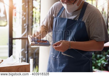 Entrepreneur  Woodwork Holding A Tacker To Assemble The Wood Pieces As The Customer Ordered