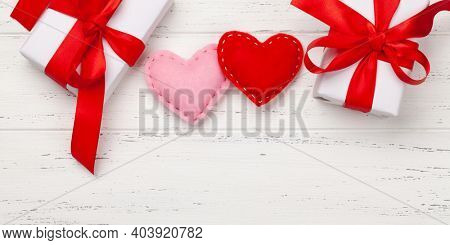 Valentines day greeting card template. Gift boxes and heart shaped decor over wooden background. Top view flat lay with copy space