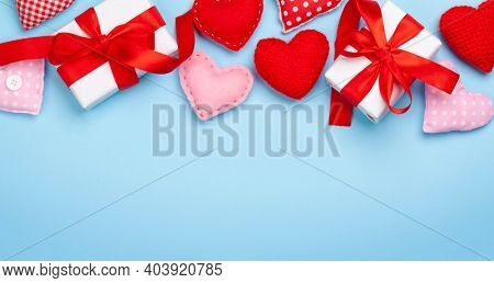 Valentines day greeting card template. Gift boxes and heart shaped decor over blue background. Top view flat lay with copy space