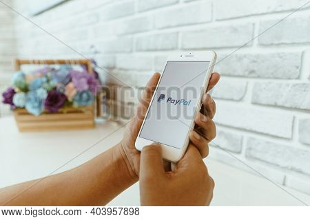 Chiang Mai, Thailand - Sep. 26,2020: Man Holding Apple Iphone 8 Plus With Paypal Apps On Screen. Pay