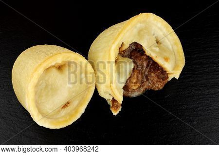 Two Individual Steamed Steak And Kidney Puddings In Suet Pastry Cases On A Slate Background
