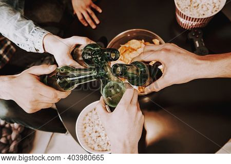 Group Of Friends Gathering Around Coffee Table At Home. Friends Gathered At The Table And Drinking B