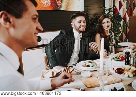 Group Of Friends Gathering Around Coffee Table At Home. Friends Gathered At The Table And Drinking B
