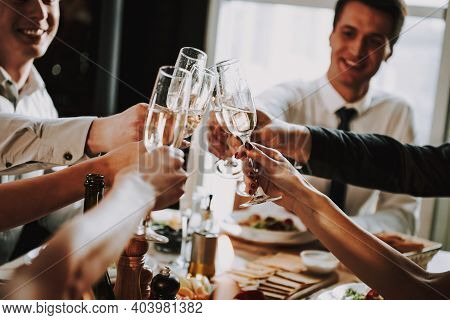 Group Of Friends Gathering Around Coffee Table At Home. Friends Gathered At The Table And Drinking B