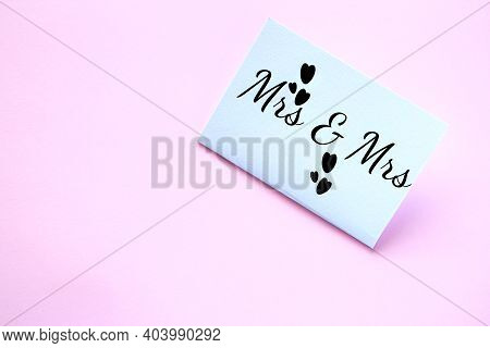 White Paper Card With The Inscription Mrs And Mrs On A Pink Background. Lesbian Wedding