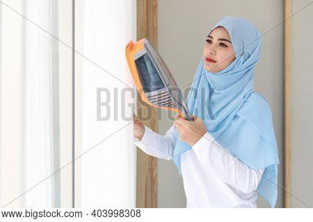 Active Young Beautiful Asian Muslim Housewife Woman Cleaning White Curtain With Vacuum Cleaning Clea