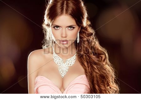Fashion Portrait Of Beautiful Woman With Long Wavy Brown Hair Style Over Dark Background