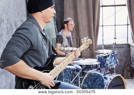 Bass guitarist and drummer play music