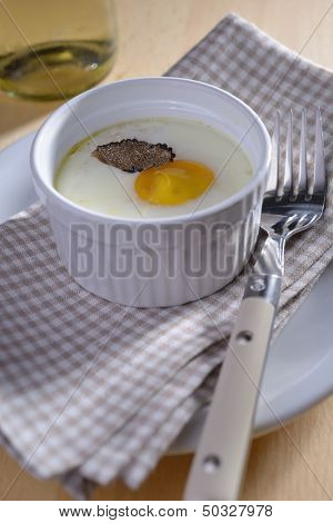 Baked egg with sliced truffle in a ramekin