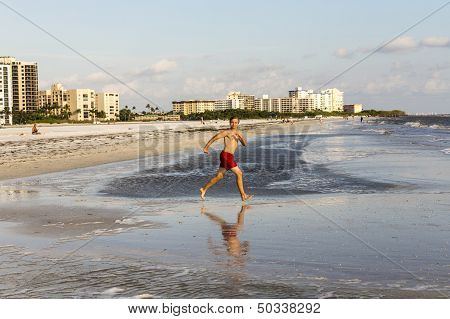 Teenager Enjoys Jogging Along The Beach