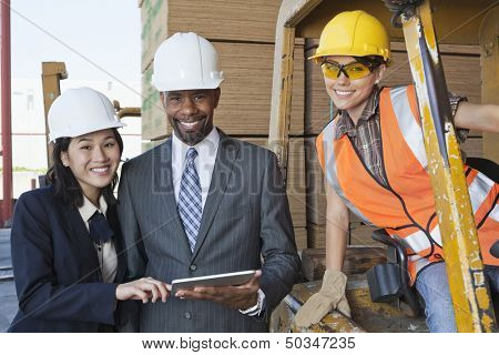 Portrait of engineers and female industrial worker smiling