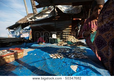 PADANG - AUGUST 25: A fishmonger attends to her customer at her stall at an outdoor market in Padang, West Sumatera, Indonesia on August 25, 2013. Resources from the sea is a major revenue earner.  