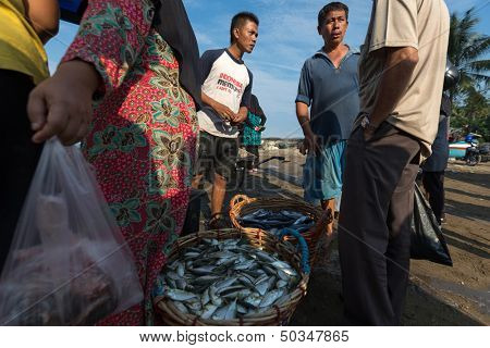 PADANG - AUGUST 25: Fishmongers negotiate fish price and trade at an outdoor village market in Padang, West Sumatera, Indonesia on August 25, 2013. Resources from the sea is a major revenue earner.