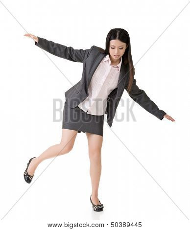 Young asian business woman standing on precipice, trying to balance. Full length portrait. Isolated on the white background.