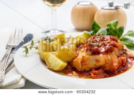 Plate of Cod or Pollack Cooked in Tomato and Thyme Sauce Garnished with Boiled New Potatoes