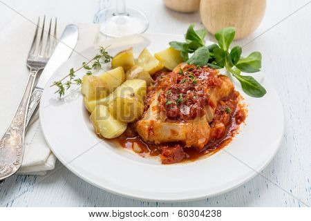 Plate of Cod or Pollack Cooked in Tomato and Thyme Sauce Garnished with Boiled New Potatoes