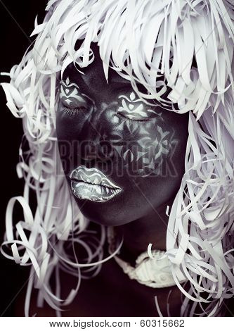 creative make up like Ethiopian mask, white pattern on black face close up