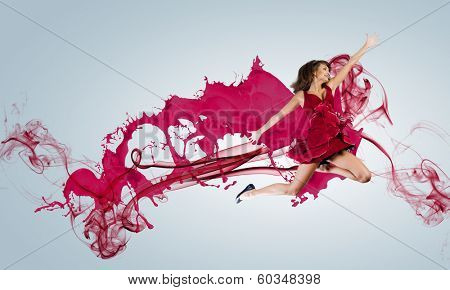 Young attractive woman in red dress jumping high