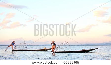 INLE LAKE, MYANMAR  DECEMBER 12, 2013: Fishermen at Inle Lake, Shan State, Myanmar Intha people possess the leg-rowing style and the unique coop-like fishing equipment