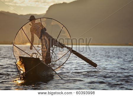 INLE LAKE, MYANMAR  DECEMBER 12, 2013: Fishermen at Inle Lake, Shan State, Myanmar Intha people possess the leg-rowing style and the unique coop-like fishing equipment