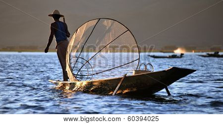 INLE LAKE, MYANMAR  DECEMBER 12, 2013: Fishermen at Inle Lake, Shan State, Myanmar Intha people possess the leg-rowing style and the unique coop-like fishing equipment