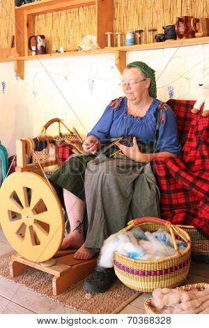 MUSKOGEE, OK - MAY 24:  A woman works at a vintage spinning wheel making yarn at the Oklahoma 19th annual Renaissance Festival on May 24, 2014 at the Castle of Muskogee in Muskogee, OK 