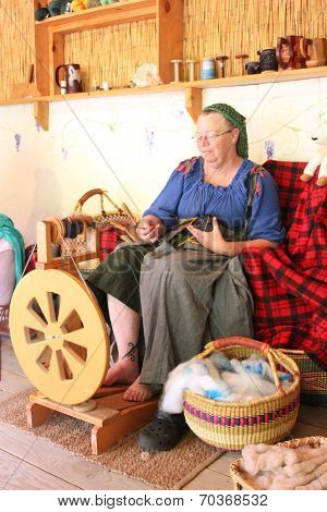 MUSKOGEE, OK - MAY 24:  A woman works at a vintage spinning wheel making yarn at the Oklahoma 19th annual Renaissance Festival on May 24, 2014 at the Castle of Muskogee in Muskogee, OK 