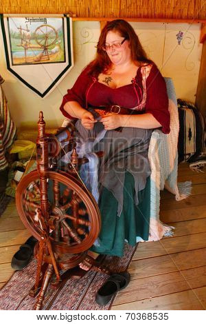 MUSKOGEE, OK - MAY 24:  A woman works at a vintage spinning wheel making yarn at the Oklahoma 19th annual Renaissance Festival on May 24, 2014 at the Castle of Muskogee in Muskogee, OK 