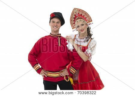 Portrait of young man and woman looking into the camera in russian traditional costumes