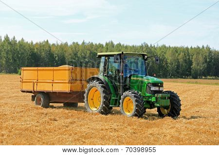 Farmer Driving John Deere 5820 Tractor And Trailer