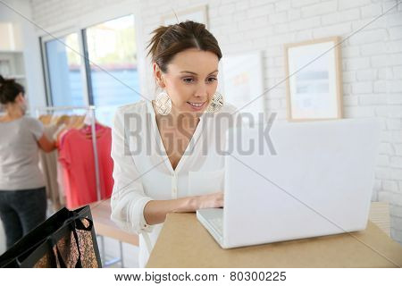 Beautiful shopgirl working in clothing store