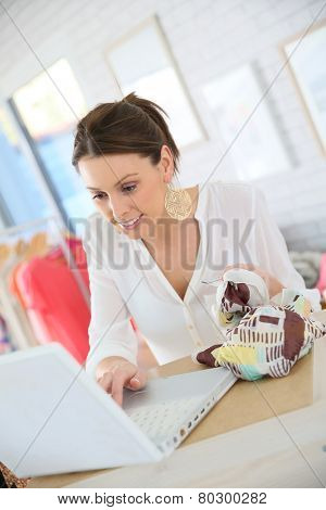 Beautiful shopgirl working in clothing store