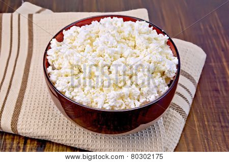 Curd in wooden bowl on board with brown cloth