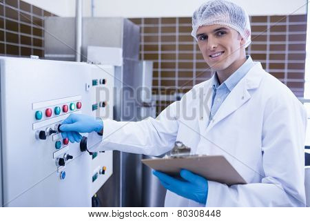 Smiling biologist using the machine in the factory