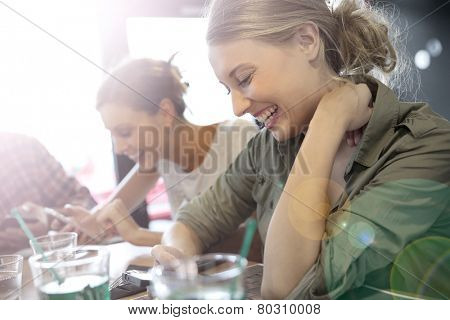 Young people in snack bar, connected on smartphone