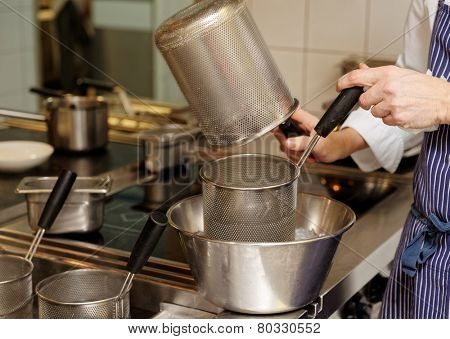 Chef is cooking food in a pasta boiler